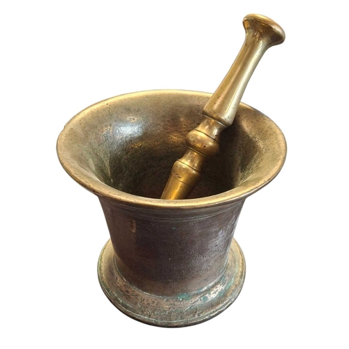 167 - An 18th century brass pestle and mortar. Having flared rim to top with rounded stepped base. Featuri... 