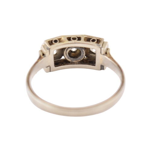 61 - An Art Deco 14ct white gold three stone diamond ring. The ring set with three diamonds within a face... 