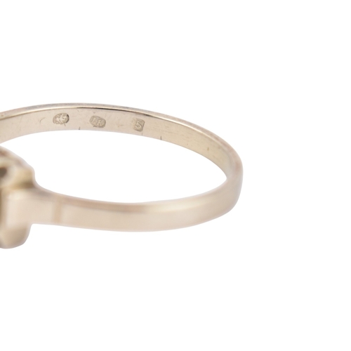 61 - An Art Deco 14ct white gold three stone diamond ring. The ring set with three diamonds within a face... 