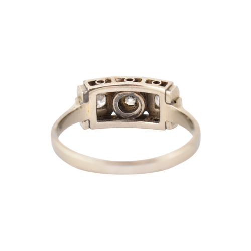 61 - An Art Deco 14ct white gold three stone diamond ring. The ring set with three diamonds within a face... 