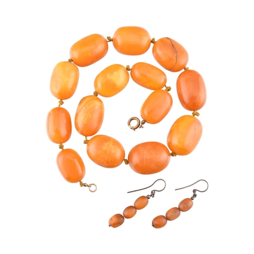 62 - A vintage egg yolk amber bead necklace and earrings. The necklace with large knotted amber beads. Th... 