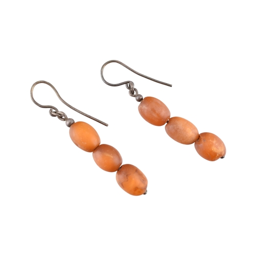 62 - A vintage egg yolk amber bead necklace and earrings. The necklace with large knotted amber beads. Th... 