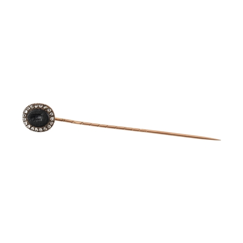 70 - A 19th century gold intaglio and diamond stickpin. The stickpin is surmounted by an intaglio of a he... 