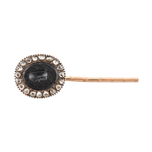70 - A 19th century gold intaglio and diamond stickpin. The stickpin is surmounted by an intaglio of a he... 