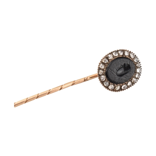 70 - A 19th century gold intaglio and diamond stickpin. The stickpin is surmounted by an intaglio of a he... 