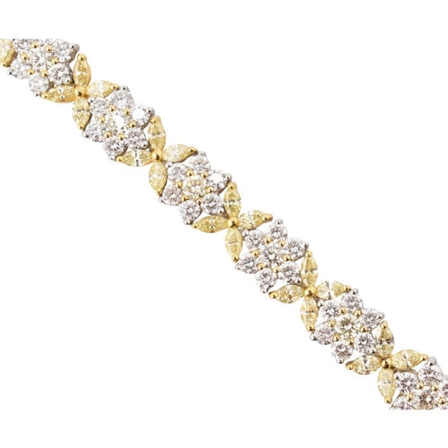 73 - An 18ct gold yellow and white diamond flower cluster necklace. The necklace with thirty-eight cluste... 