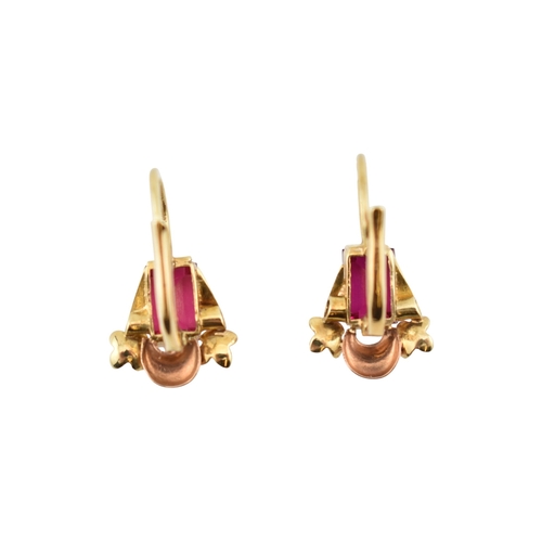 77 - A pair of 14ct gold and synthetic ruby pendant earrings. The earrings set with emerald cut synthetic... 