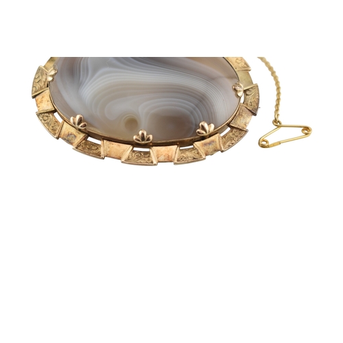 84 - An early 20th century yellow metal and agate brooch pin. Weight 22.4g. Measures 5.5cm. Unmarked surf... 