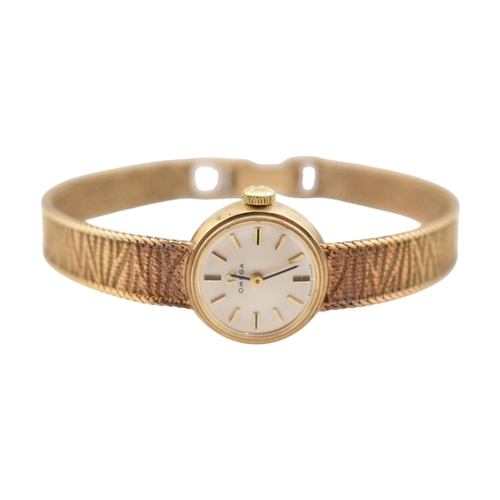 96 - A hallmarked 9ct gold Omega wristwatch and strap. The silvered dial with baton markers. Set with ori... 
