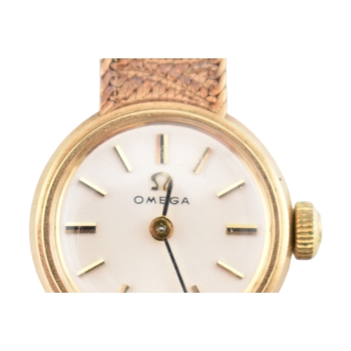 96 - A hallmarked 9ct gold Omega wristwatch and strap. The silvered dial with baton markers. Set with ori... 