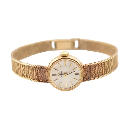 96 - A hallmarked 9ct gold Omega wristwatch and strap. The silvered dial with baton markers. Set with ori... 