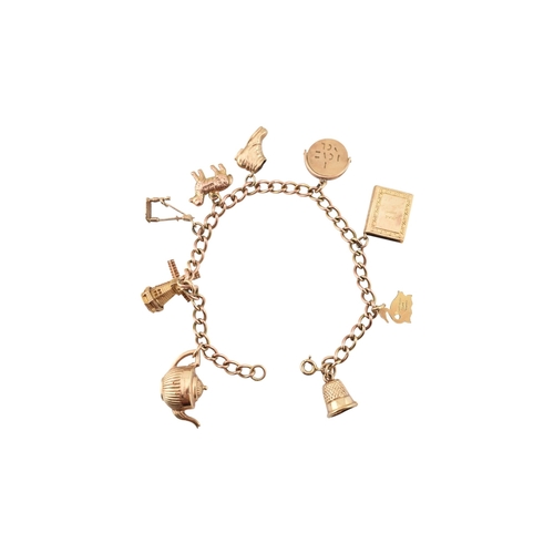 99 - A 9ct gold charm bracelet. The bracelet strung with multiple charms to include a hallmarked bell, a ... 