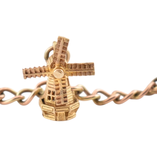 99 - A 9ct gold charm bracelet. The bracelet strung with multiple charms to include a hallmarked bell, a ... 