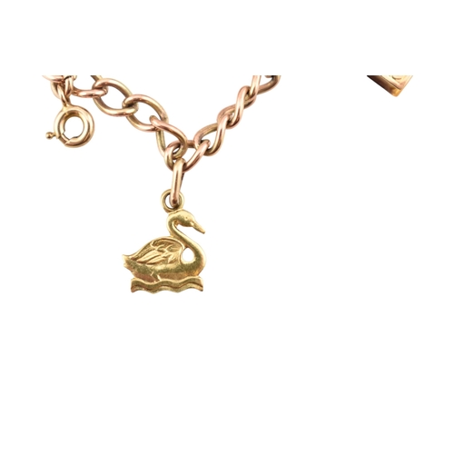 99 - A 9ct gold charm bracelet. The bracelet strung with multiple charms to include a hallmarked bell, a ... 