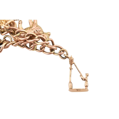 99 - A 9ct gold charm bracelet. The bracelet strung with multiple charms to include a hallmarked bell, a ... 