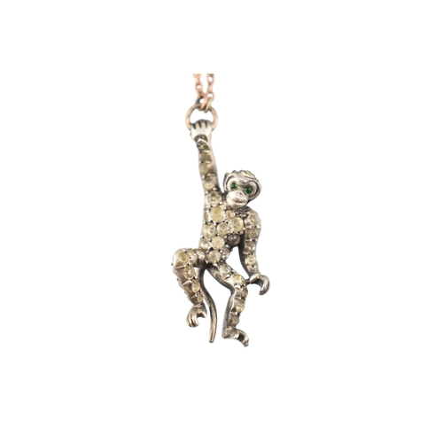 101 - A 1920s silver and gold pin paste set monkey pendant brooch pin. The brooch with a monkey sat upon a... 