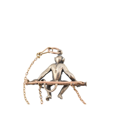 101 - A 1920s silver and gold pin paste set monkey pendant brooch pin. The brooch with a monkey sat upon a... 