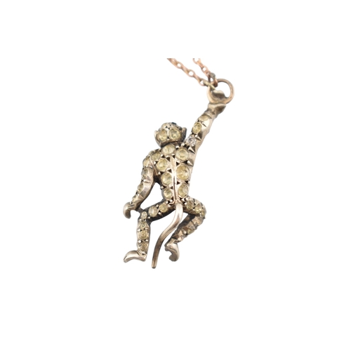 101 - A 1920s silver and gold pin paste set monkey pendant brooch pin. The brooch with a monkey sat upon a... 