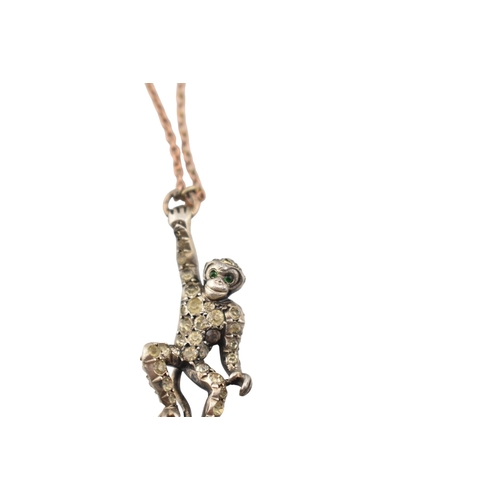 101 - A 1920s silver and gold pin paste set monkey pendant brooch pin. The brooch with a monkey sat upon a... 
