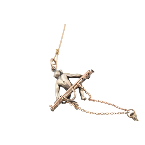 101 - A 1920s silver and gold pin paste set monkey pendant brooch pin. The brooch with a monkey sat upon a... 