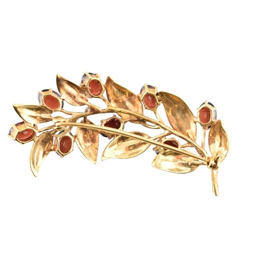 107 - A hallmarked 9ct gold and garnet spray brooch pin. The brooch is set with oval cut garnets within te... 