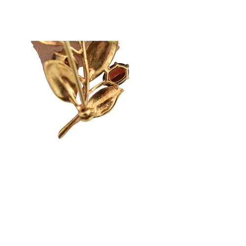 107 - A hallmarked 9ct gold and garnet spray brooch pin. The brooch is set with oval cut garnets within te... 