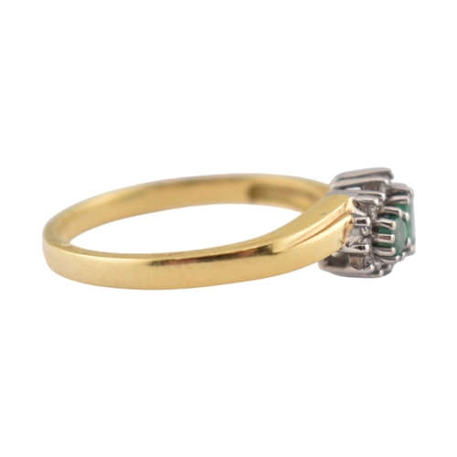 188 - A hallmarked 18ct gold emerald and diamond three stone ring. The ring set with three emeralds framed... 