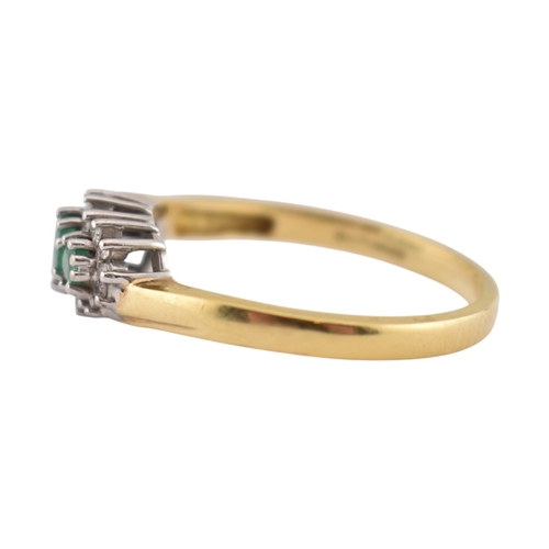 188 - A hallmarked 18ct gold emerald and diamond three stone ring. The ring set with three emeralds framed... 