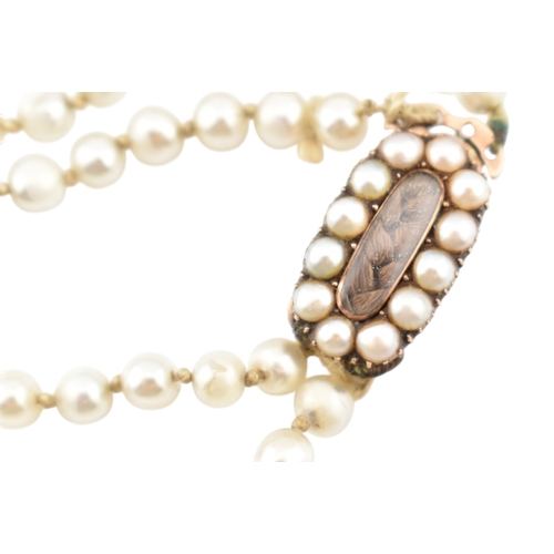 194 - A 19th century simulated glass pearl necklace with a mourning hair locket clasp. The clasp having a ... 