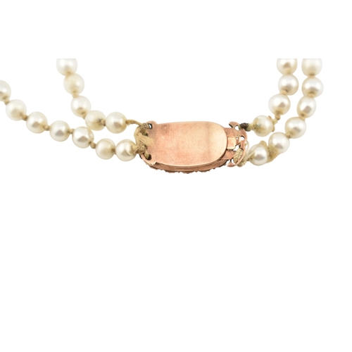 194 - A 19th century simulated glass pearl necklace with a mourning hair locket clasp. The clasp having a ... 