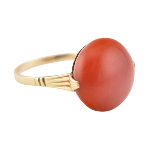 203 - An Art Deco 14ct gold & and coral cabochon ring. The ring set with a large round coral cabochon ... 