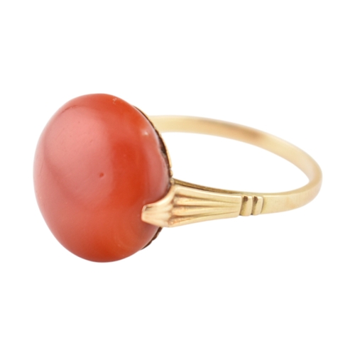 203 - An Art Deco 14ct gold & and coral cabochon ring. The ring set with a large round coral cabochon ... 
