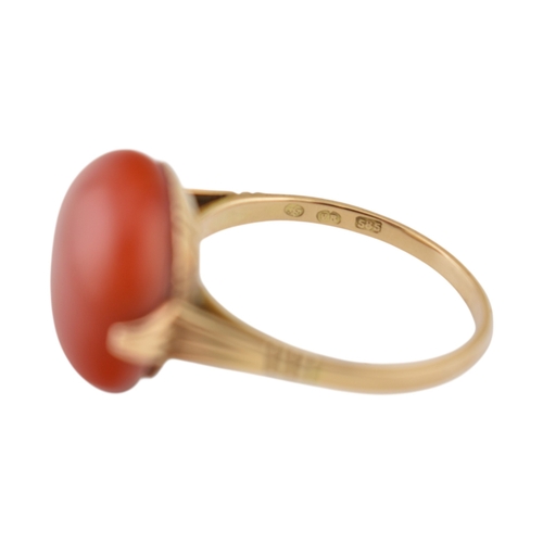 203 - An Art Deco 14ct gold & and coral cabochon ring. The ring set with a large round coral cabochon ... 