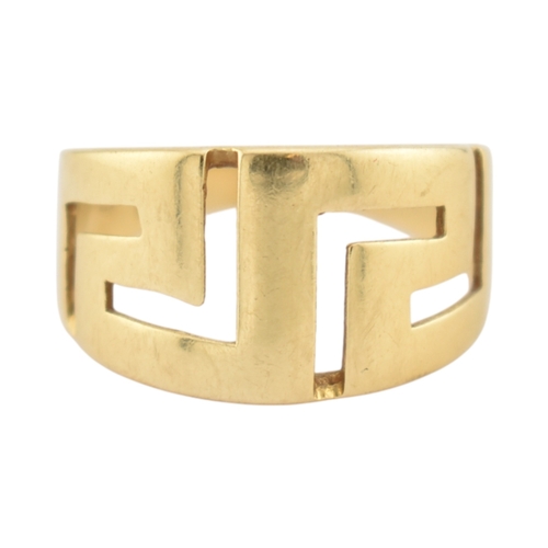 216 - An 18ct gold band ring. The ring with pierced Greek key decoration. Stamped 750. Weight 5.9g. Size R... 