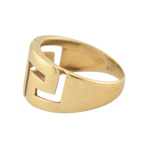 216 - An 18ct gold band ring. The ring with pierced Greek key decoration. Stamped 750. Weight 5.9g. Size R... 