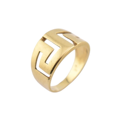 216 - An 18ct gold band ring. The ring with pierced Greek key decoration. Stamped 750. Weight 5.9g. Size R... 
