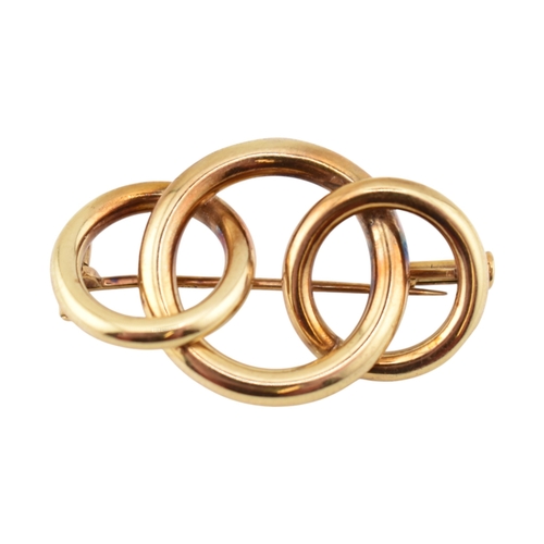 225 - A retro 14ct gold Knot brooch pin. The brooch with three entwined concentric circles to a trombone c... 
