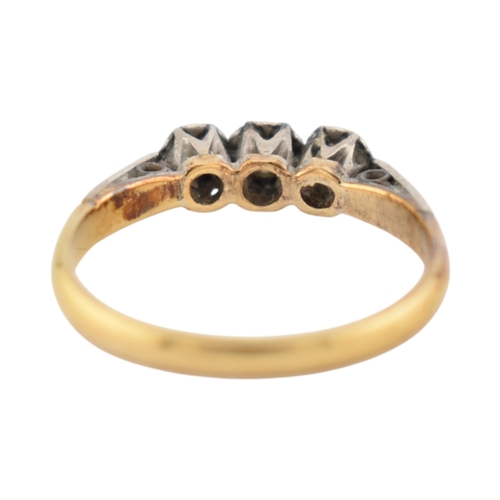 229 - An 18ct gold and platinum three stone diamond ring. Stamped 18ct & Plat. Weight 1.8g. Size K... 