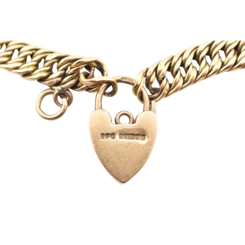 335 - A 15ct gold fancy link bracelet adorned with a 9ct gold hallmarked heart padlock. Stamped 15ct to br... 