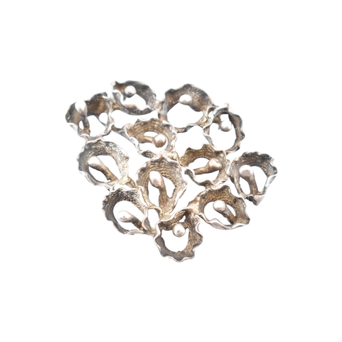 342 - A large abstract flower cluster pendant. Marks to bail illegible. Weight 37.8g. Measures 6.5cm... 