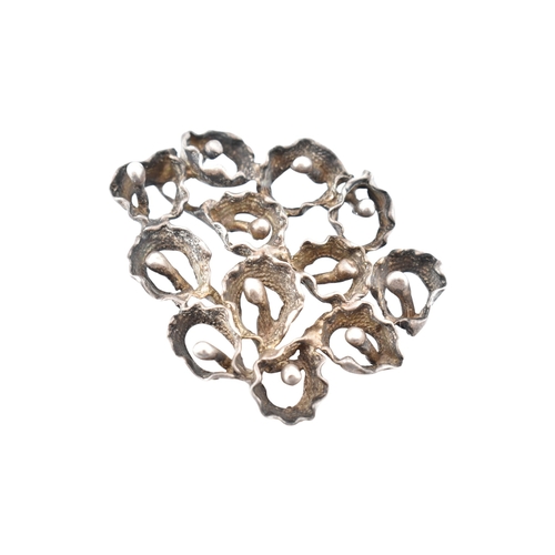 342 - A large abstract flower cluster pendant. Marks to bail illegible. Weight 37.8g. Measures 6.5cm... 