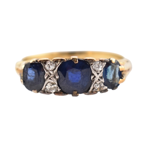 354 - An 18ct gold sapphire and diamond three stone ring. Stamped 18ct. Weight 2.8g. Size J