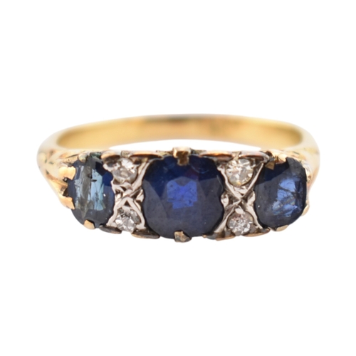 354 - An 18ct gold sapphire and diamond three stone ring. Stamped 18ct. Weight 2.8g. Size J