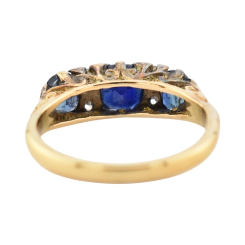 354 - An 18ct gold sapphire and diamond three stone ring. Stamped 18ct. Weight 2.8g. Size J