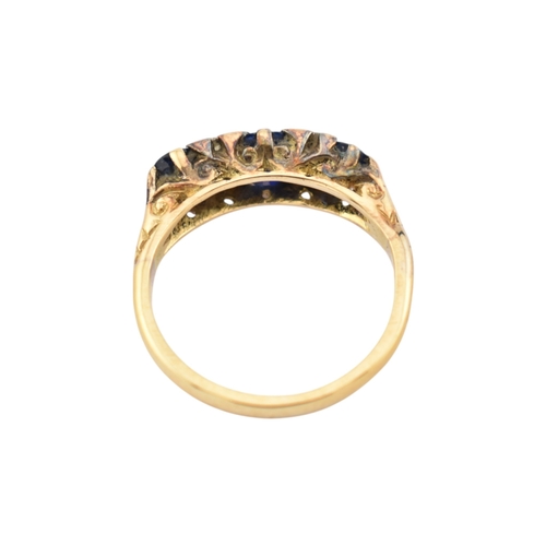 354 - An 18ct gold sapphire and diamond three stone ring. Stamped 18ct. Weight 2.8g. Size J