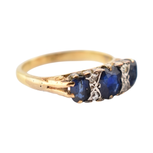 354 - An 18ct gold sapphire and diamond three stone ring. Stamped 18ct. Weight 2.8g. Size J