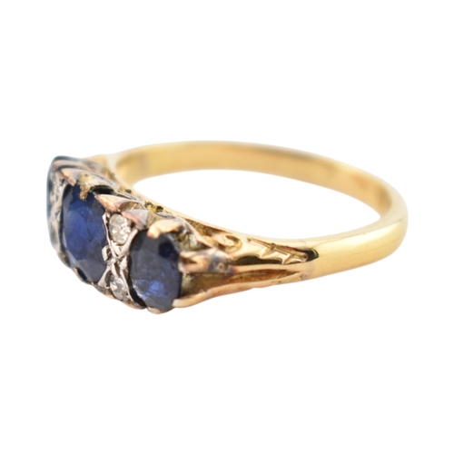 354 - An 18ct gold sapphire and diamond three stone ring. Stamped 18ct. Weight 2.8g. Size J