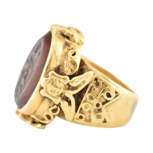 355 - A gold intaglio ring. The ring with a central intaglio depicting a warrior set within an ornate moun... 
