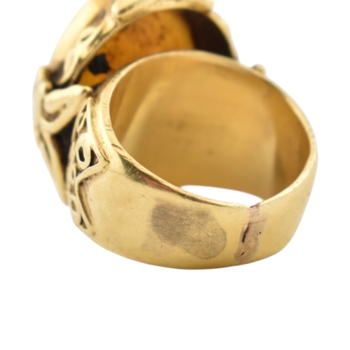 355 - A gold intaglio ring. The ring with a central intaglio depicting a warrior set within an ornate moun... 