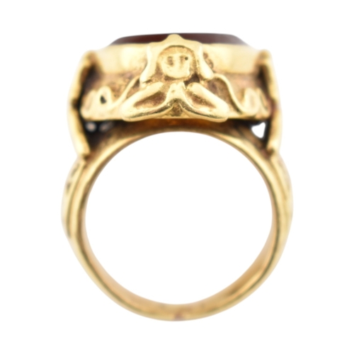 355 - A gold intaglio ring. The ring with a central intaglio depicting a warrior set within an ornate moun... 